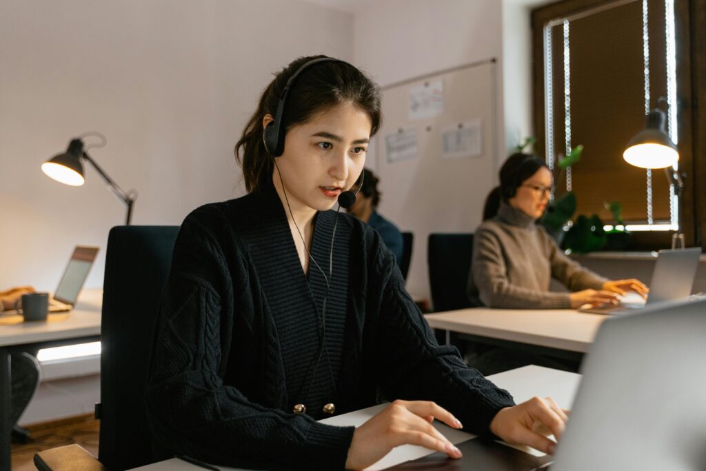 Focused call center agents working with headsets in a modern office environment.
