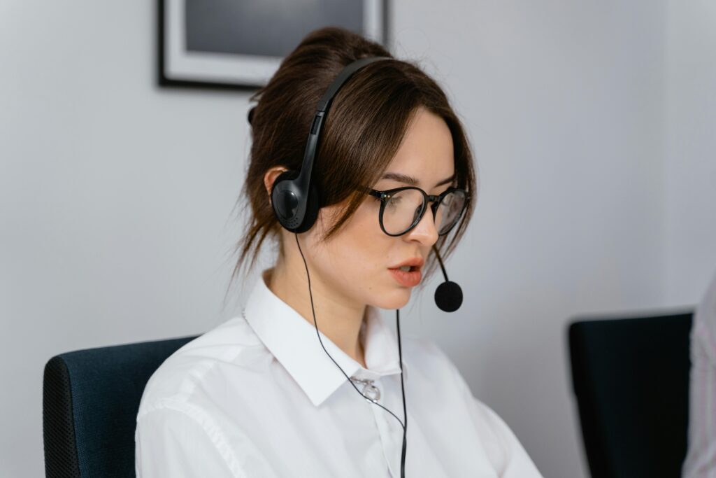 pexels-photo-7709224-7709224-1 Focused woman working in a call center with a headset, providing customer support and communication services.